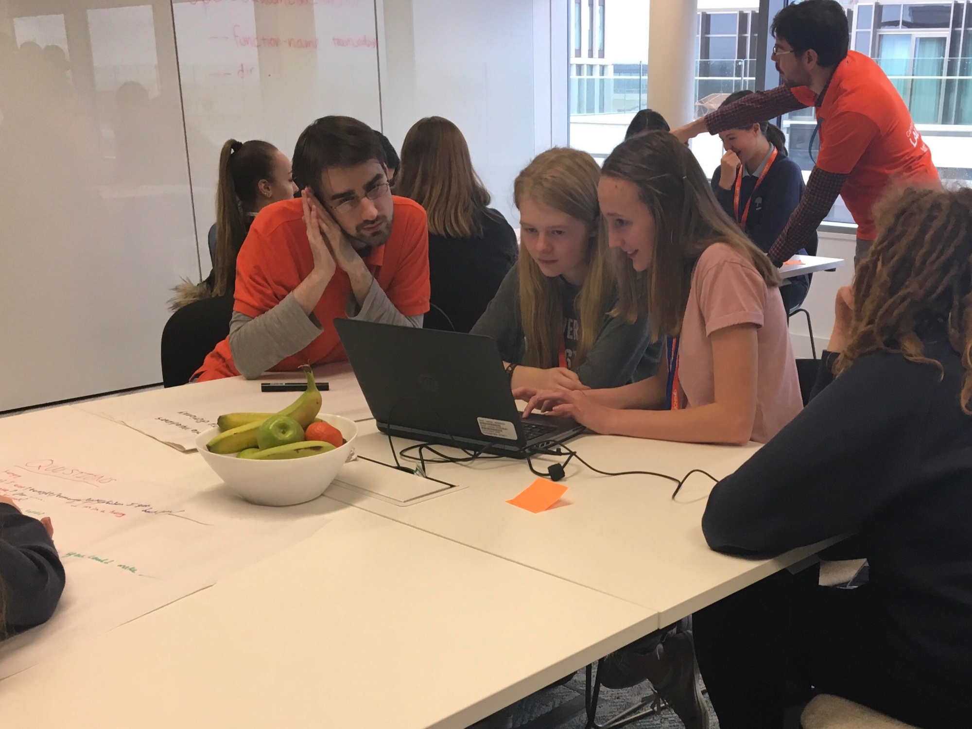 Two students look at a computer with an Amazon employee