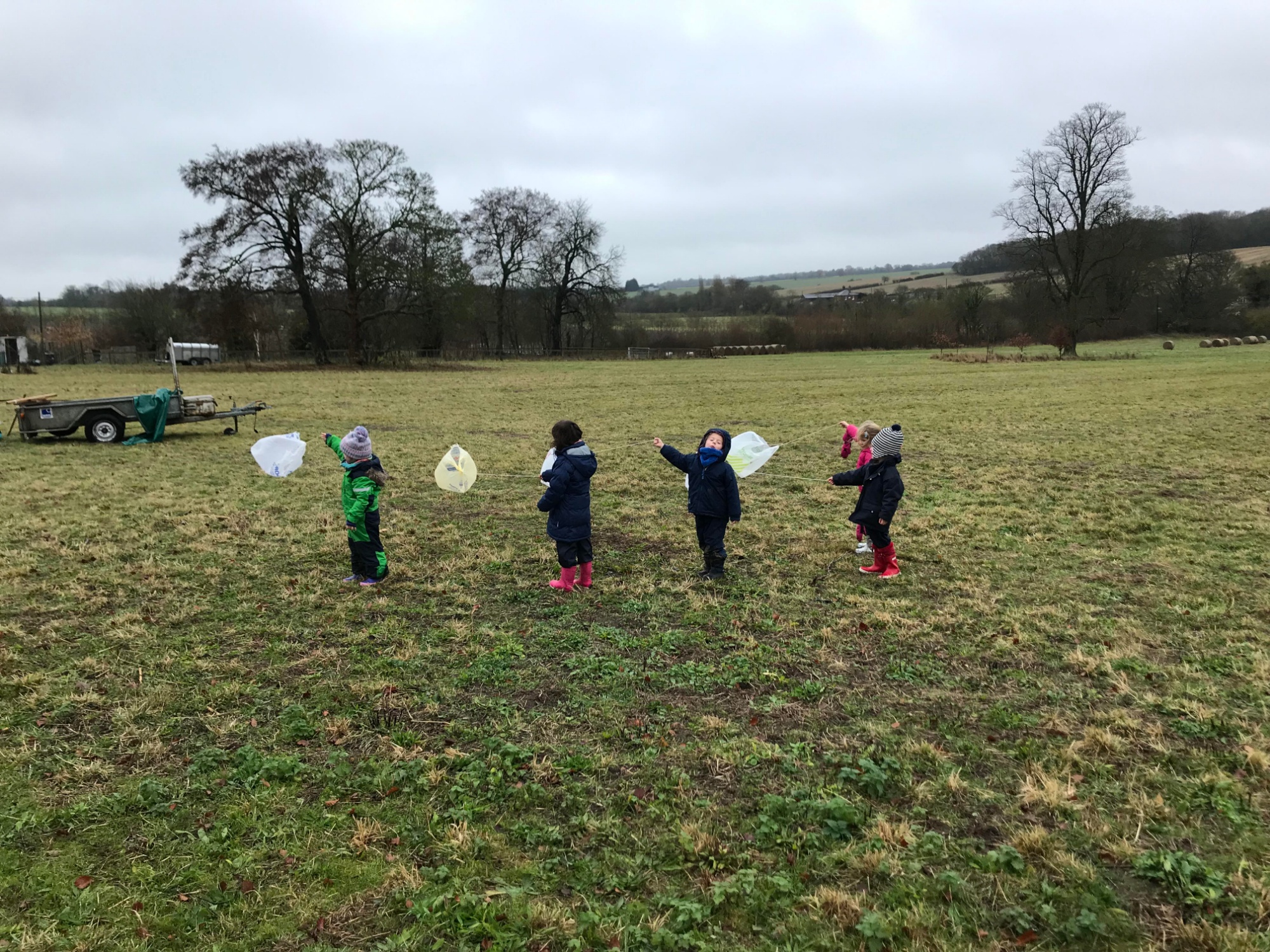 Reception pupils wave kites made out of plastic bag