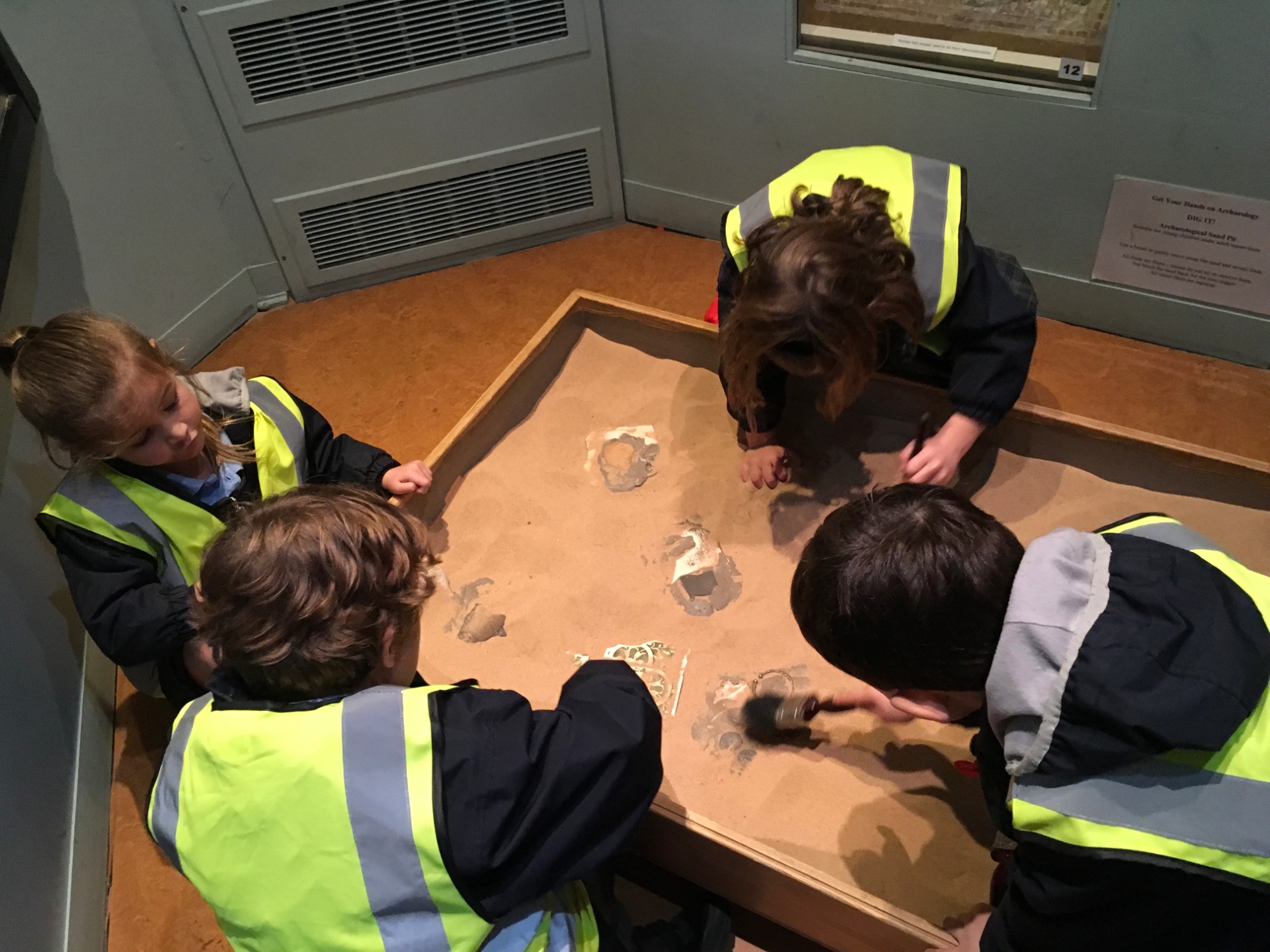 The pupils dig for artefacts in sand