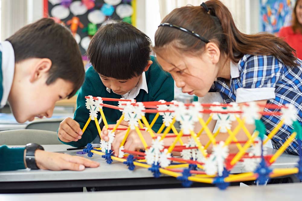 Trhee children in class building a project